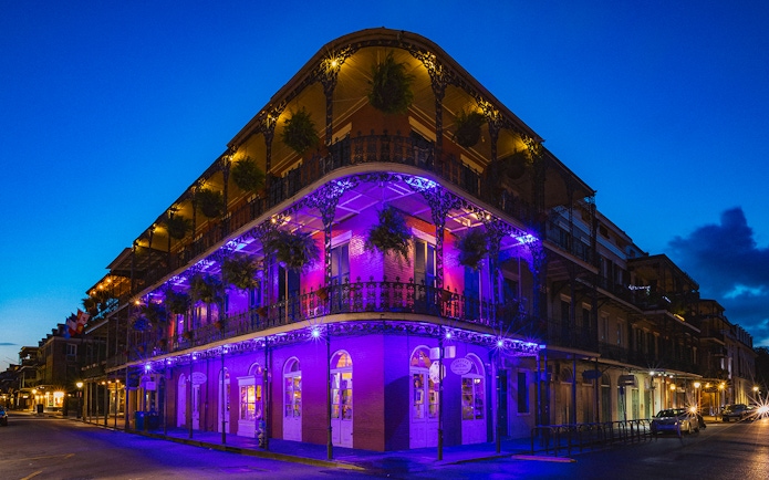 Bourbon Street balconies illuminated at night in New Orleans.