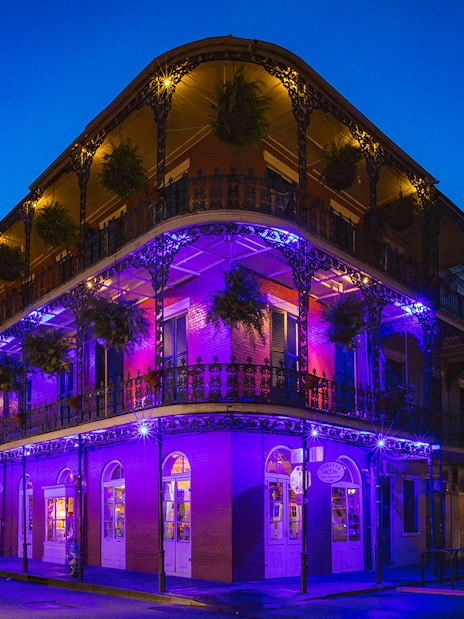 Bourbon Street balconies illuminated at night in New Orleans.