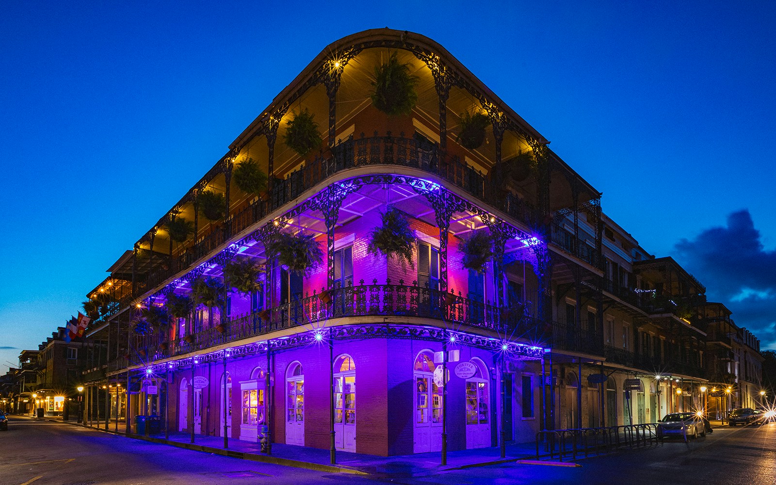Bourbon Street balconies adorned with colorful flags in New Orleans.