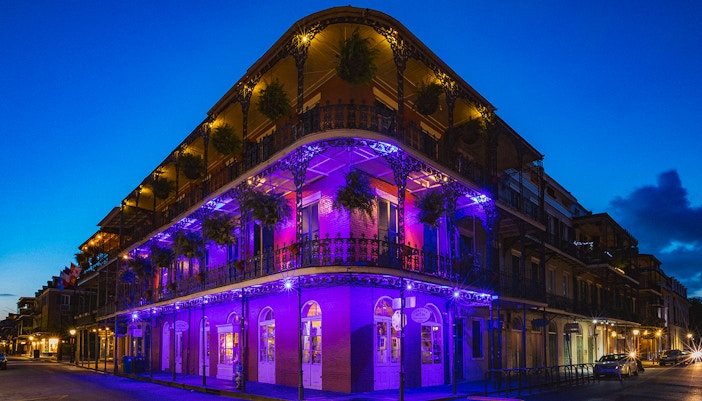 Bourbon Street balconies illuminated at night in New Orleans.
