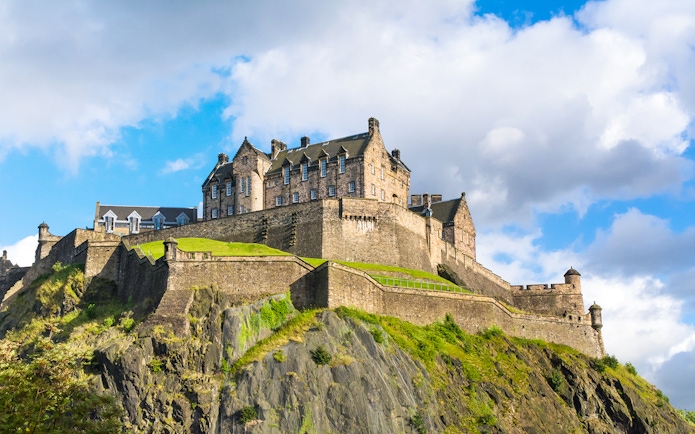 Edinburgh Castle on Castle Rock, Scotland, under a blue sky.
