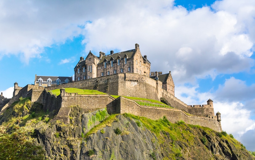 Edinburgh Castle on Castle Rock, Scotland, under a blue sky.