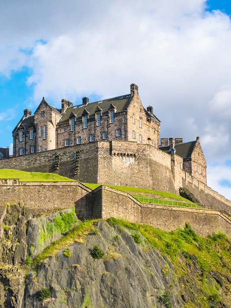 Edinburgh Castle on Castle Rock, Scotland, under a blue sky.