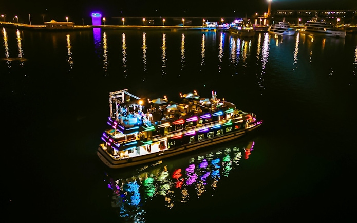 Luxury cruise with colorful lights at night in Ha Long Bay.