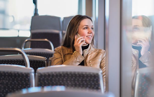 Woman on a bus talking on the phone during Cairo tour transfer.