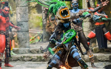 Traditional Mayan performance at Xcaret Park with dancers in vibrant costumes.