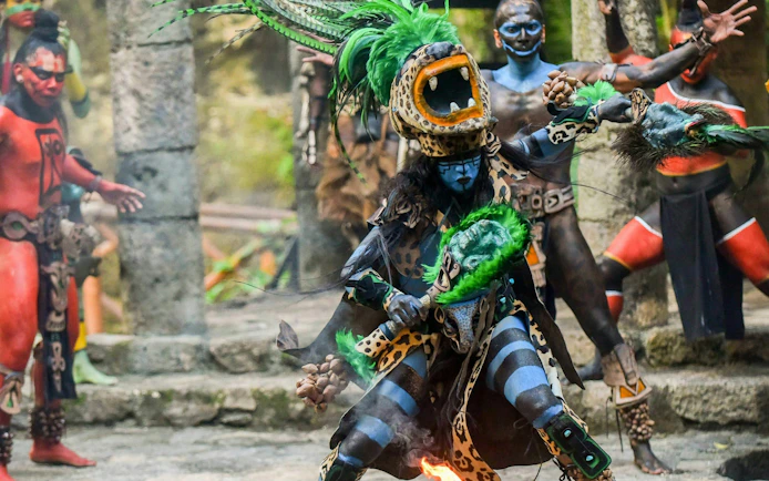 Traditional Mayan performance at Xcaret Park with dancers in vibrant costumes.