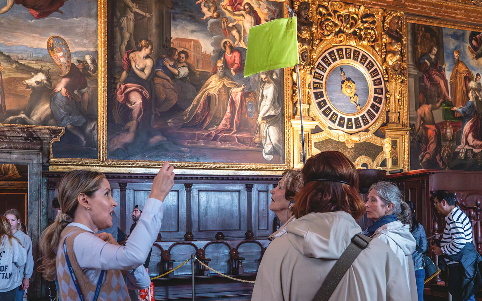 Tour group observing artwork and clock inside Doge's Palace, Venice.