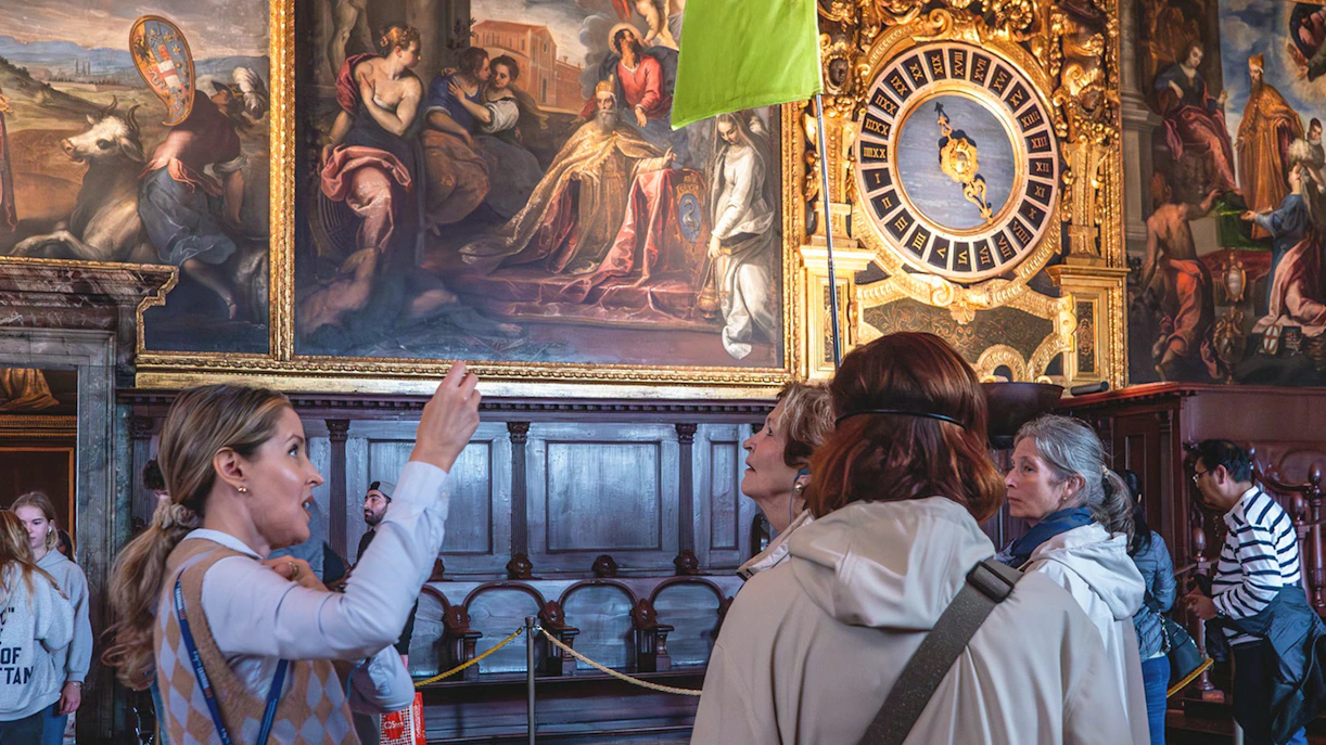 Tour group observing artwork and clock inside Doge's Palace, Venice.