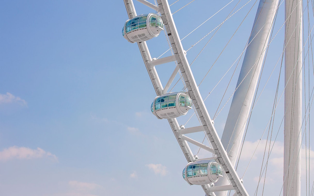 Pods of Ain Dubai against a clear blue sky.