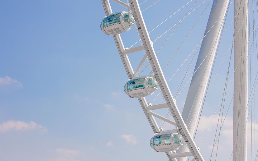 Pods of Ain Dubai Ferris wheel against a clear blue sky.