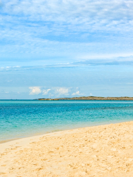 Sailboat anchored near sandy beach at Allen Cay, Exumas, Bahamas.
