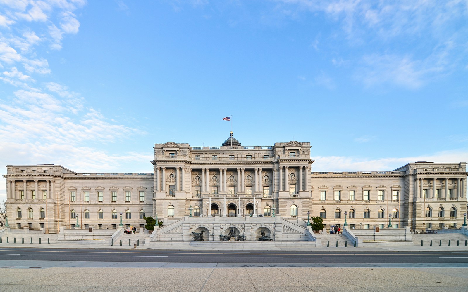 Library of Congress building facade in Washington D.C. with American flag.