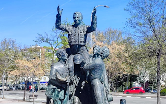 Statue of bullfighter being lifted by supporters in Madrid, seen on a private 2-hour tour.