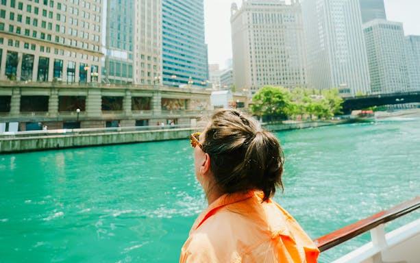 Person on a boat enjoying the Chicago River Architecture Tour with city skyline views.