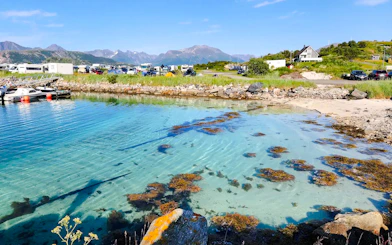 Clear waters of Sommarøy Fjord with distant mountains, Tromsø.