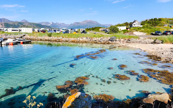 Clear waters of Sommarøy Fjord with distant mountains, Tromsø.