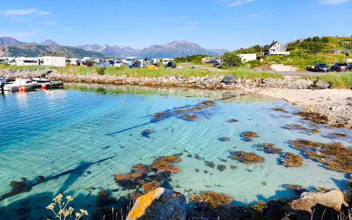 Clear waters of Sommarøy Fjord with distant mountains, Tromsø.