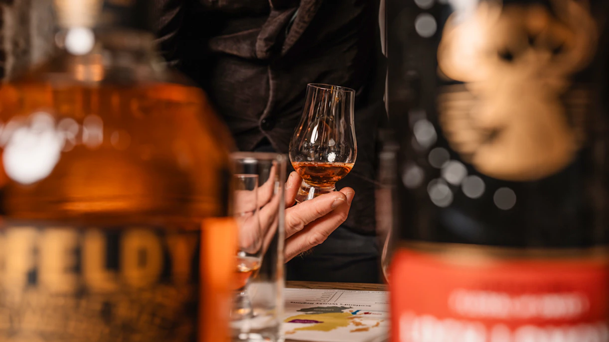 Hand holding whisky glass during tasting on Edinburgh underground tour.