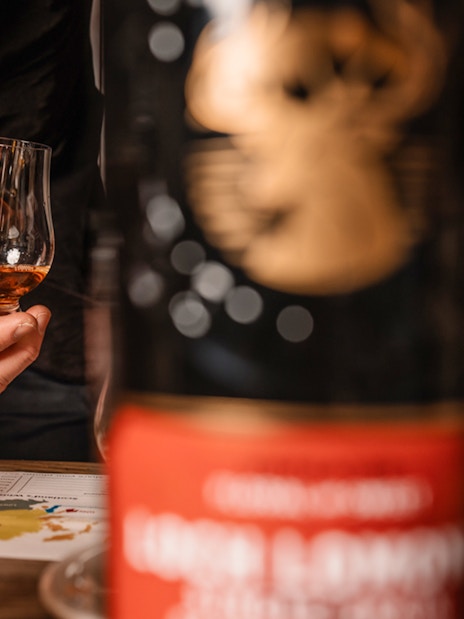 Hand holding whisky glass during tasting on Edinburgh underground tour.