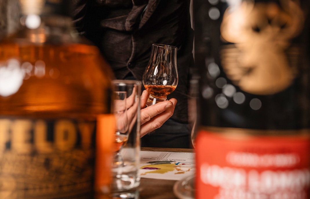 Hand holding whisky glass during tasting on Edinburgh underground tour.