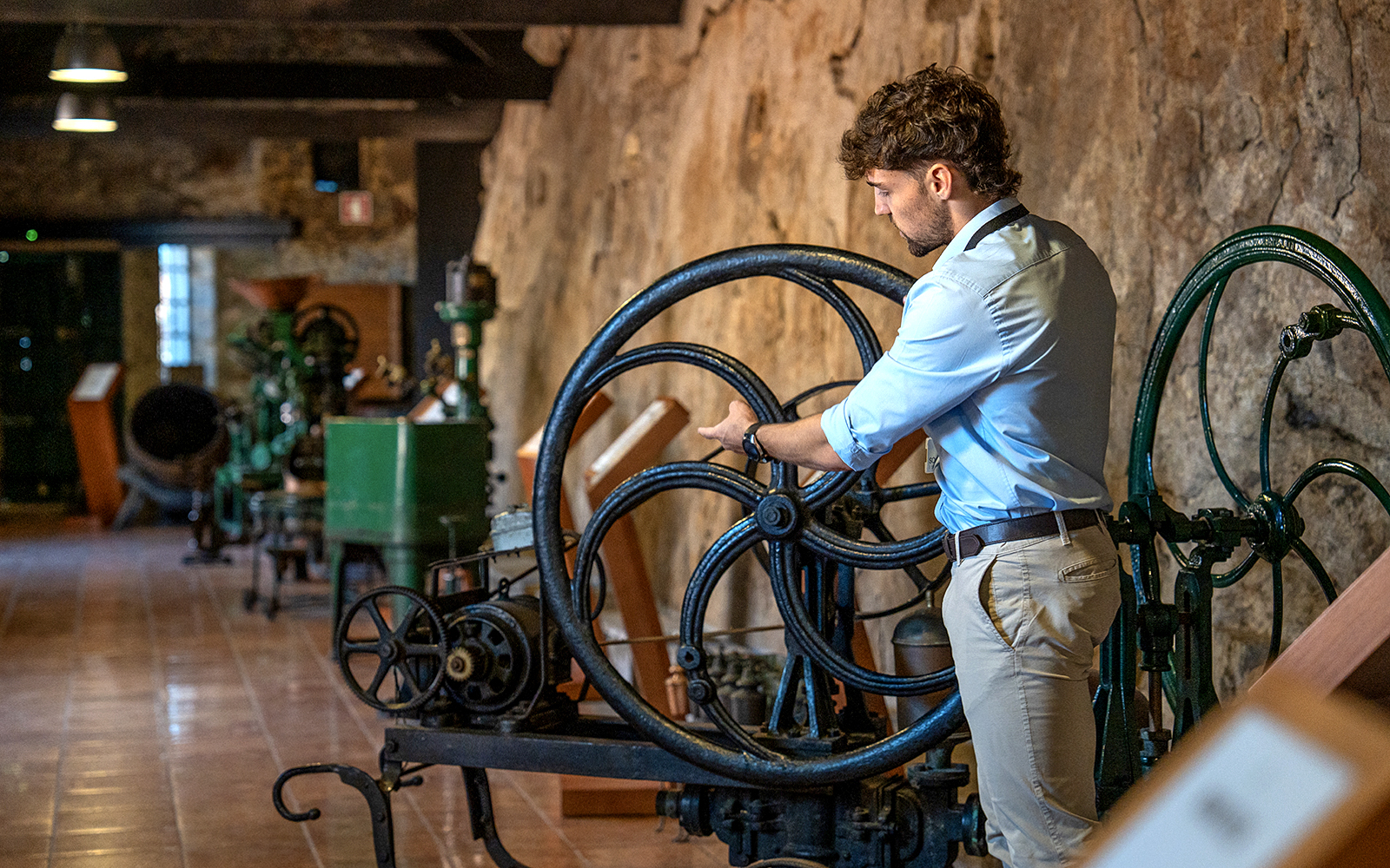 Man operating vintage wine machinery in Porto winery.