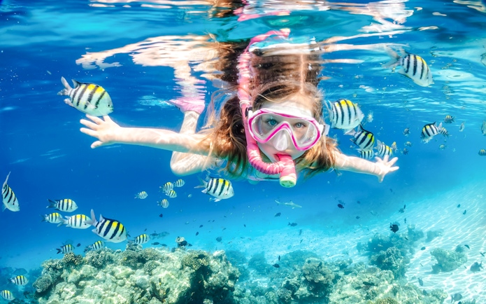 Girl snorkelling among fish at White Island, Sharm El-Sheikh.