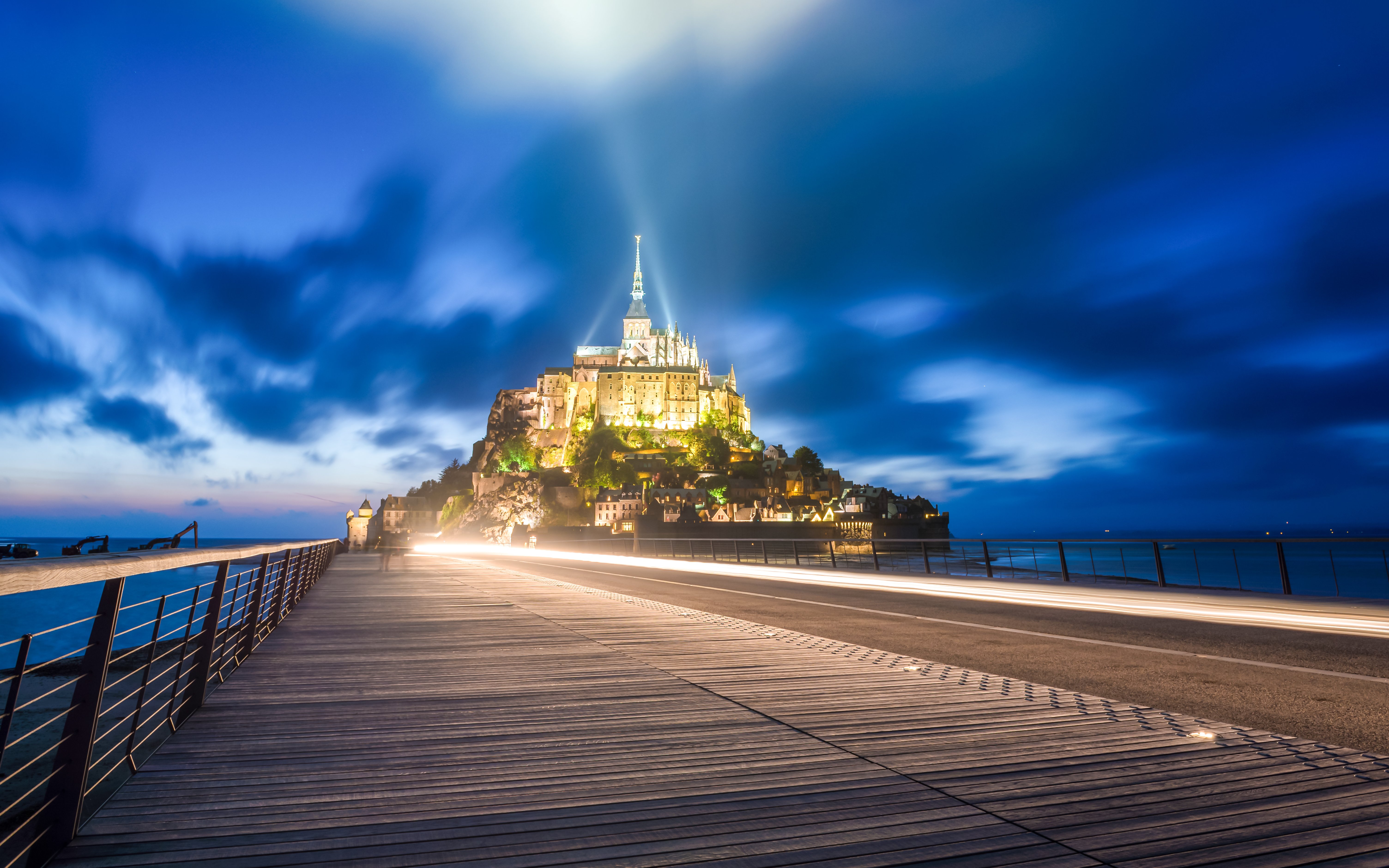 Mont Saint Michel illuminated at night during the Nocturnes show, view from the bridge.