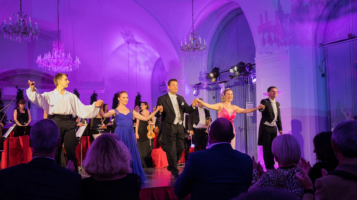 Performers bowing on stage during Blue Danube Waltz concert on boat tour.