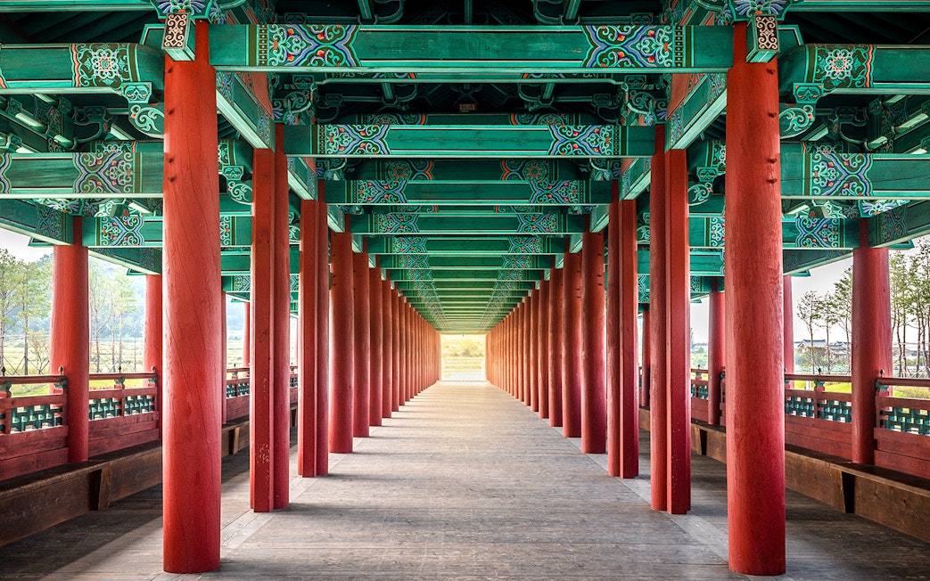 Traditional Korean architecture with red columns and ornate ceiling in Gyeongju, South Korea.