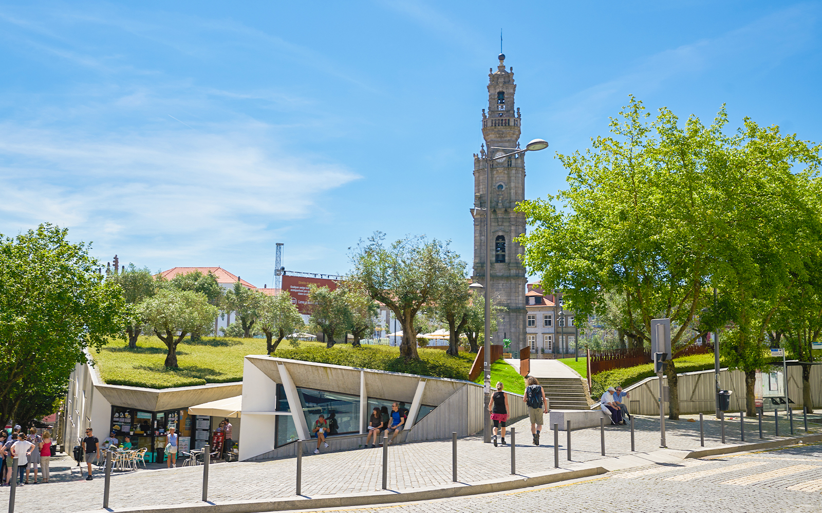 Clérigos Tower in Porto with surrounding park and visitors walking nearby.