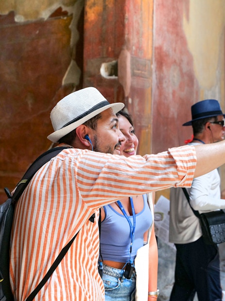 Tourists exploring ancient frescoes at Pompeii ruins.