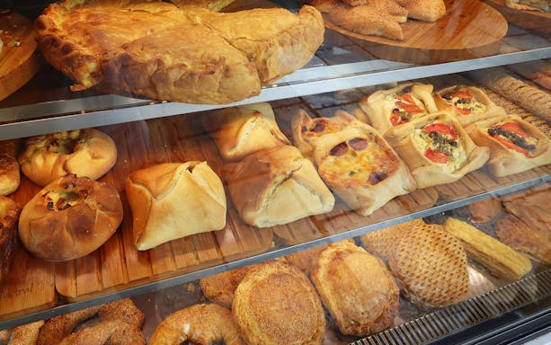 Assorted Greek pastries in a bakery display during Athens street food tour.