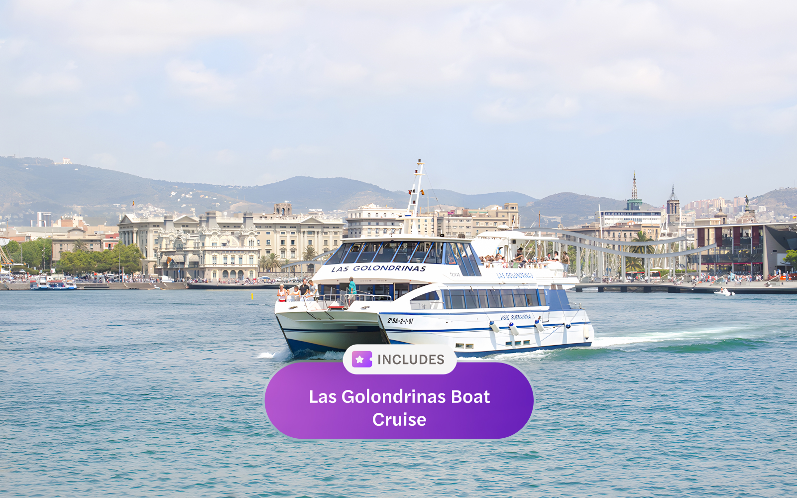 Las Golondrinas boat cruising in Barcelona harbor with cityscape in the background.