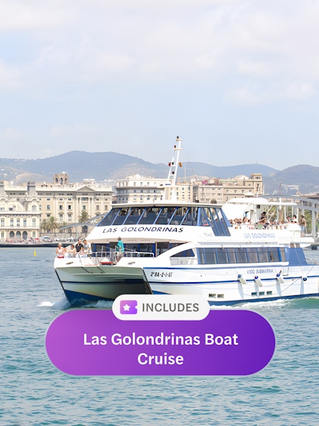 Las Golondrinas boat cruising in Barcelona harbor with cityscape in the background.