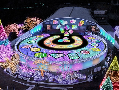 Yomiuriland illuminated night display with colorful lights and geometric patterns.