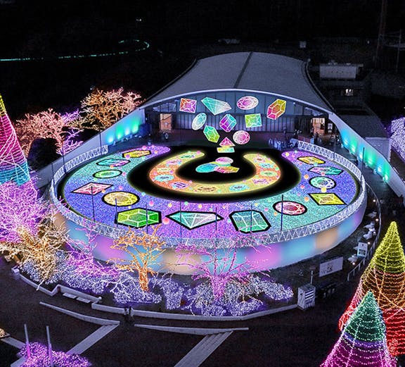 Yomiuriland illuminated night display with colorful lights and geometric patterns.
