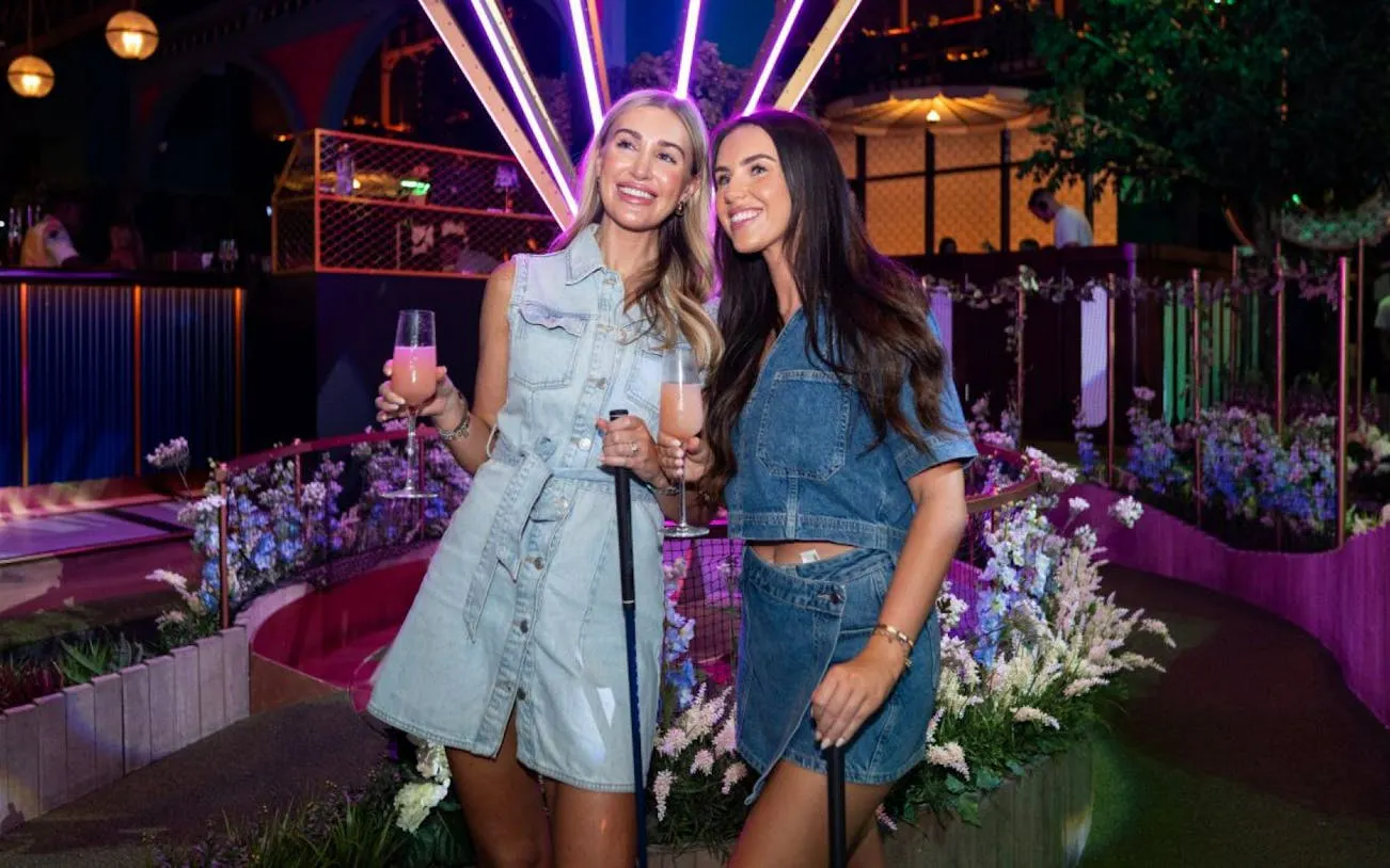 Guests enjoying mini golf with drinks at Swingers venue.
