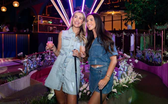 Guests enjoying mini golf with drinks at Swingers venue.