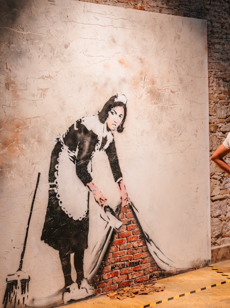 Tourist viewing Banksy artwork at Banksy Museum in Barcelona.