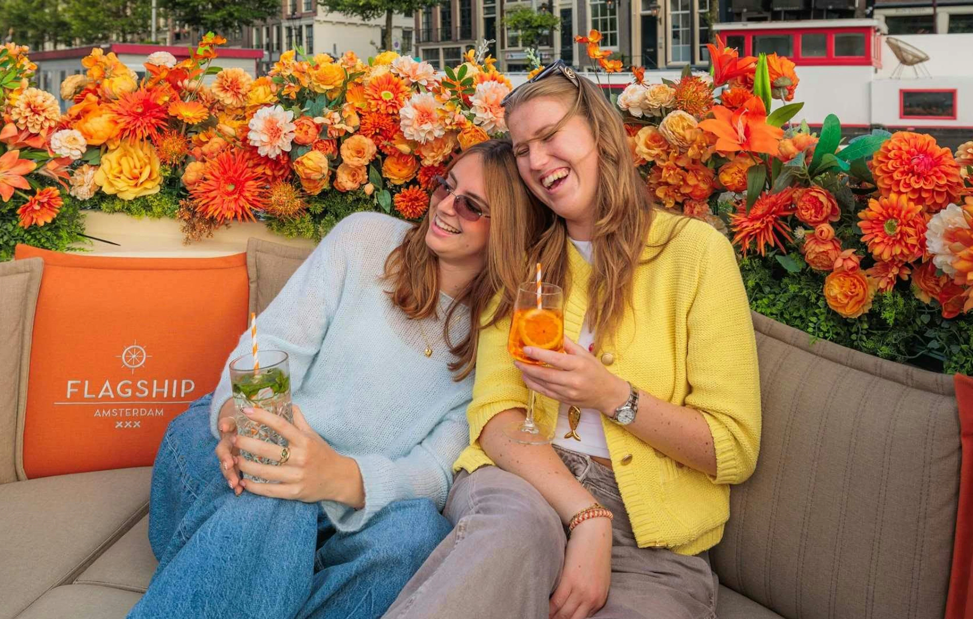 Guests enjoying drinks on a luxury boat canal cruise in Amsterdam.