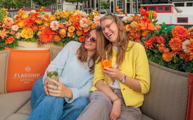 Guests enjoying drinks on a luxury boat canal cruise in Amsterdam.