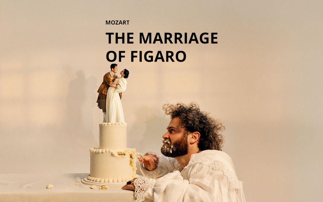 Man eating cake with figurines of a couple on top, referencing "The Marriage of Figaro.