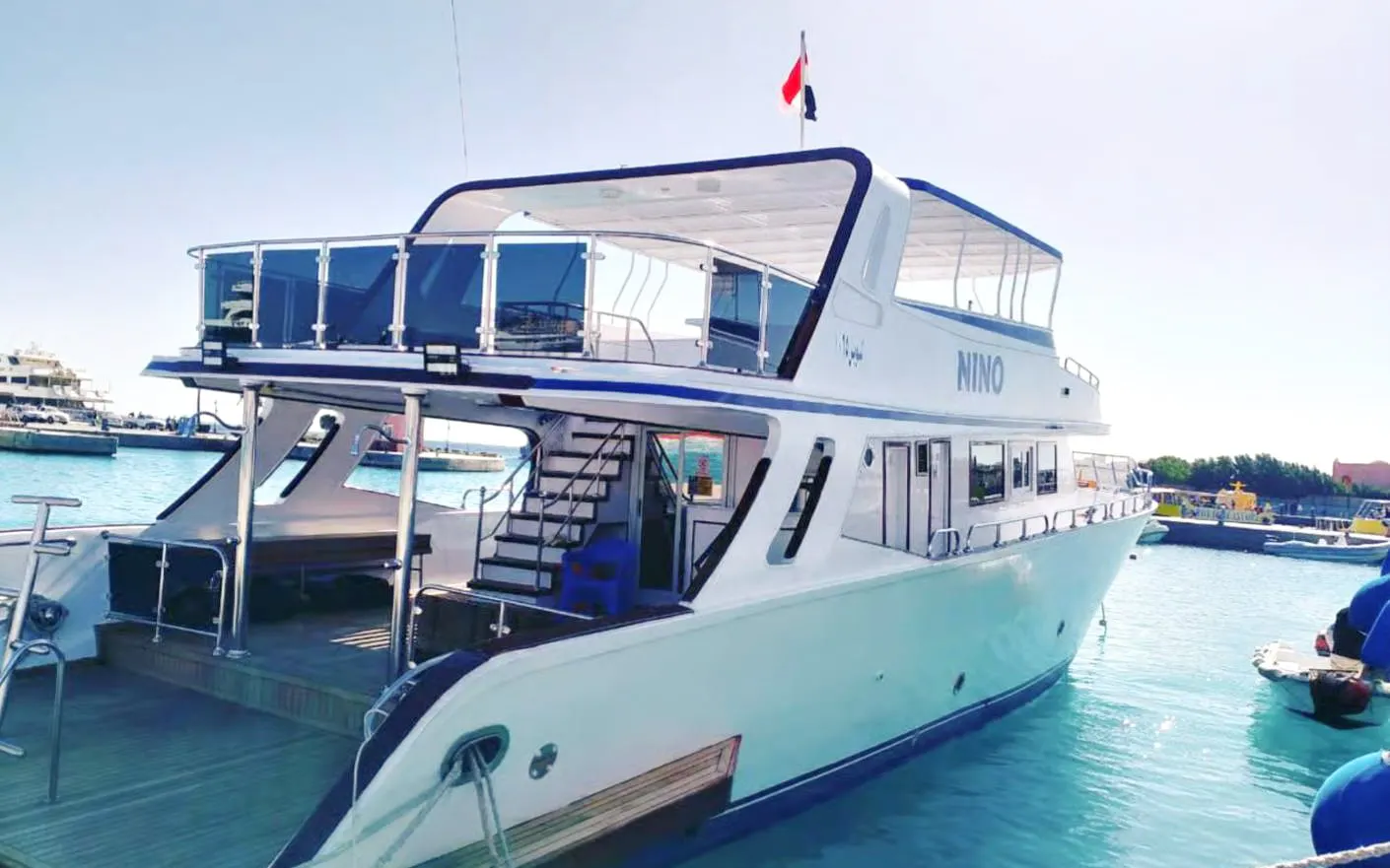 Luxury boat docked in Hurghada marina for sunset dive, dolphin watching, snorkeling, and lunch tour.