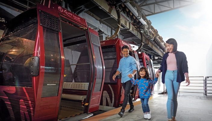 Family boarding cable car at Genting Awana SkyWay, Malaysia.