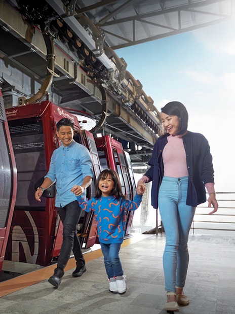 Family boarding cable car at Genting Awana SkyWay, Malaysia.