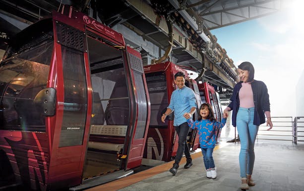 Family boarding cable car at Genting Awana SkyWay, Malaysia.