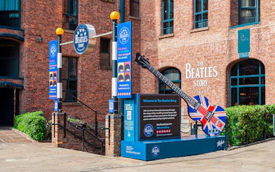 Exteriors of The Beatles Story museum in Liverpool with signage and Union Jack guitar display.