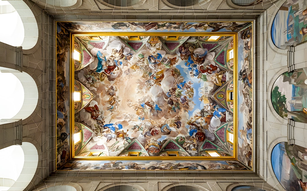 Ceiling fresco in San Lorenzo de El Escorial, depicting vibrant historical and religious scenes.