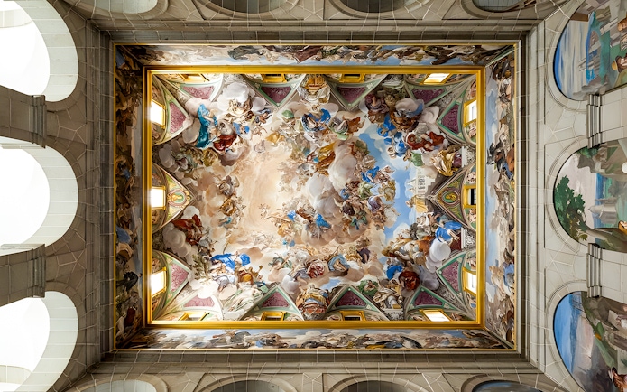 Ceiling fresco in San Lorenzo de El Escorial, depicting vibrant historical and religious scenes.